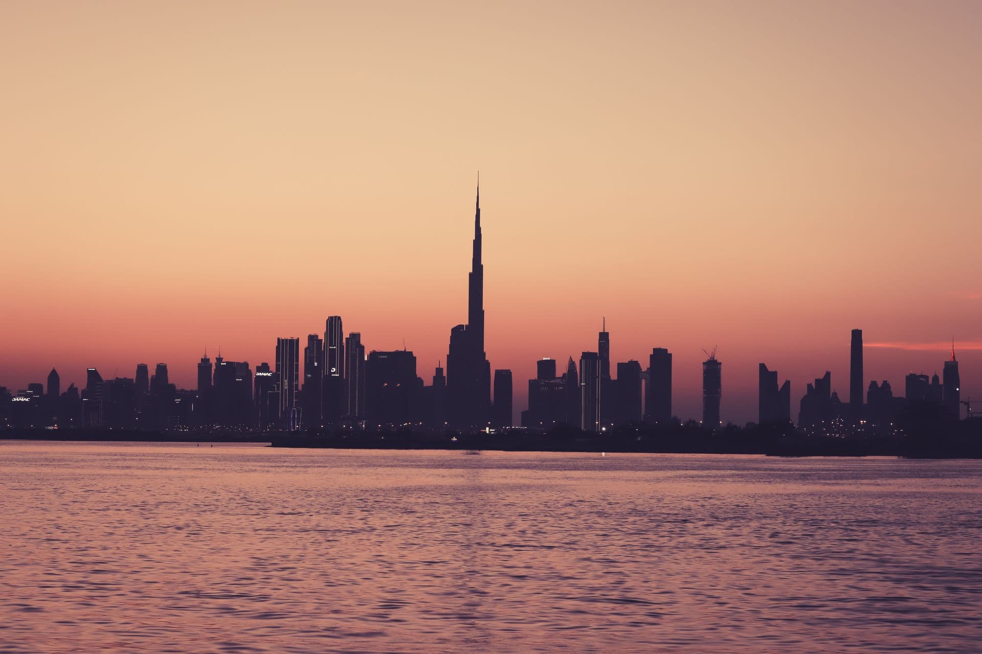 Gulf city skyline at dusk, skyscrapers silhouetted over the water